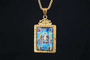 Macro shot of gold Thangka Buddha pendant with intricate filigree and blue details
