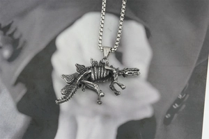Macro view of vintage silver steampunk stegosaurus skeleton pendant with textured box chain