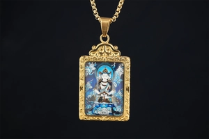 Macro detail of golden thangka pendant necklace with intricate Buddhist deity artwork