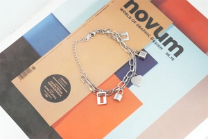 Detail view of double-layer stainless steel heart and lock charms on mixed-link chains