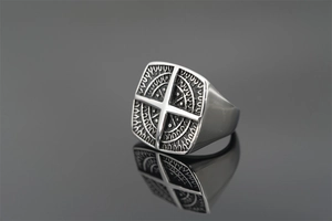 Macro shot of a punk style square signet ring with a compass star and viking runes