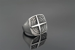 Detailed macro of a vintage punk titanium steel square ring with a cross and totem motifs