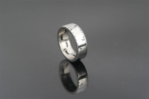 Macro shot of silver titanium steel tape measure ring with engraved scales and numbers
