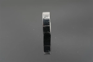 Macro shot of silver titanium steel ring featuring realistic measuring ruler scale engraving