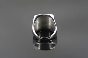 Macro shot of minimalist silver titanium steel ring with polished finish on dark mirror