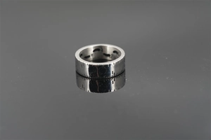 Macro detail of silver tape measure ring with engraved scale and tiny footprints inside