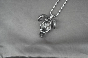 Détail d'un pendentif crâne de taureau vintage avec cornes en spirale sur chaîne