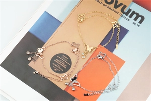 Detail of butterfly pendant double-layered bracelet in gold, rose gold and silver