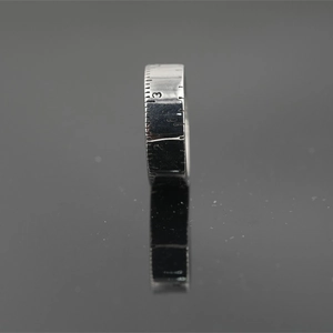 Titanium steel silver tape measure ring with engraved scale numbers on dark background
