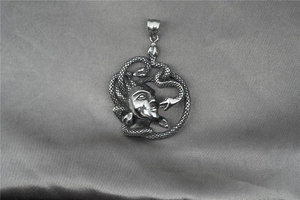 Dettaglio macro del ciondolo Medusa con intricato rilievo di serpente in acciaio inox