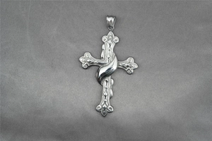 Gros plan d'un pendentif croix gothique en argent avec des gravures florales détaillées et chic