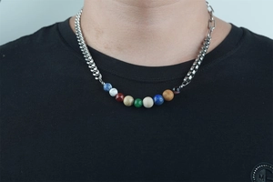 Vue détaillée du pendentif planète et de la chaîne asymétrique en acier hip-hop