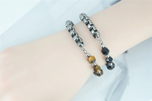 Detailed shot of tiger eye and black matte stone beads on steel link bracelet