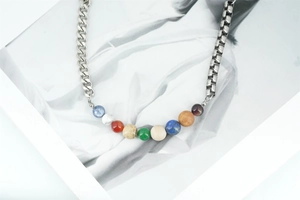 Détail du collier de perles planète DIY avec chaîne asymétrique en acier et pierres colorées