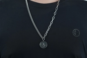 Collier chaîne asymétrique avec pendentif pièce de monnaie et mains en prière