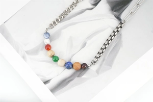 Gros plan détaillé d'un collier chaîne mixte avec perles de pierre naturelle sur un magazine