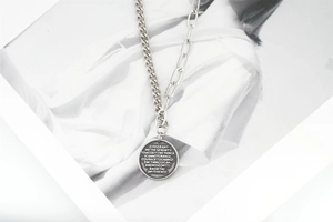 Détail du collier chaîne asymétrique avec pendentif pièce de monnaie Serenity Prayer gravé