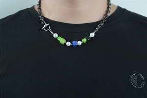 Detail of beaded necklace featuring green stone beads and vintage OT toggle clasp