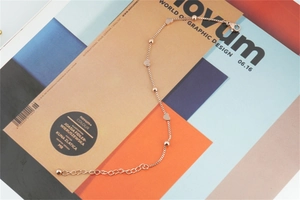 Detail showing rose gold heart and ball charms on a refined titanium steel chain link