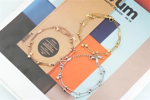 Detail view of double-layer stainless steel star charm bracelets in gold and rose gold