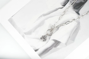 Détail macro de la chaîne en acier titane avec boucle OT et pendentif boîte Paris