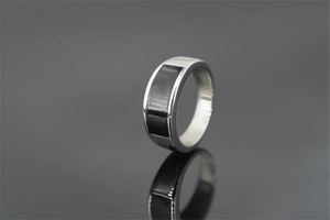 Polished silver titanium steel ring with black rectangular inlay on mirror background