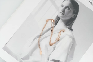 Vue détaillée du bracelet double couche en or rose avec pendentifs cœur et fermoir homard
