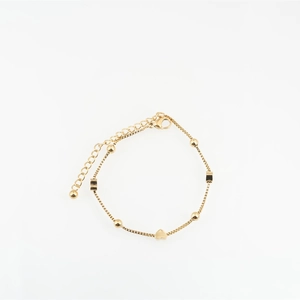 Gold box chain bracelet with heart charm and delicate beads on a minimalist white background