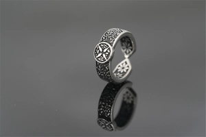 Macro detail of a vintage titanium steel ring with floral textures and cross emblem