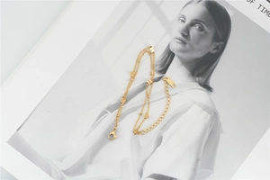 Vue détaillée du bracelet double couche en acier doré avec petits pendentifs en cœur
