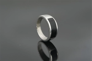 Macro shot of silver stainless steel ring with rectangle black enamel inlay detail