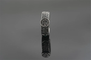 Macro detail of retro titanium steel ring with embossed emblem and oxidized finish