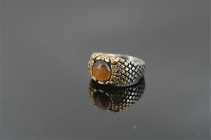 Dettaglio macro dell'anello vintage da uomo con pietra occhio di tigre e trama a scaglie