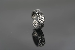 Macro shot of retro gothic style steel ring with cross emblem and ornate engravings
