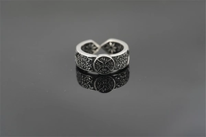 Macro shot of vintage style titanium steel ring with embossed solar star emblem detail