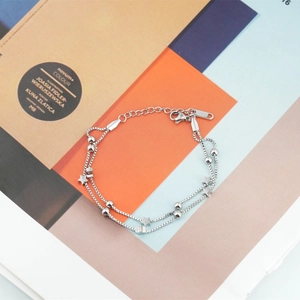 Double-layered stainless steel star bracelet with silver beads on a colorful background