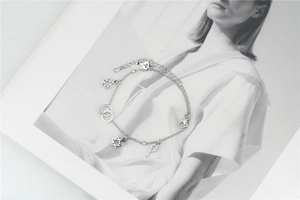 Detailed macro view of silver titanium steel bracelet with hexagram and key charms