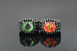 Close-up of gothic eagle claw rings with detailed green and red evil eye glass inlays