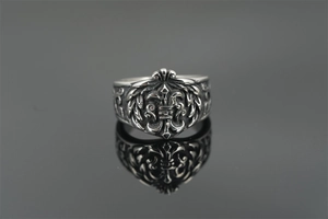 Macro shot of retro stainless steel ring with fleur-de-lis engraving and punk details