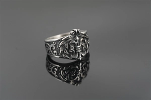 Macro shot of vintage gothic punk ring featuring a detailed fleur-de-lis engraving on steel
