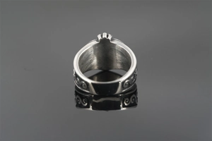 Detail of vintage punk titanium steel ring featuring black oxidized scrollwork and brushed metal
