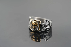 Macro view of punk skull ring detail with golden relief and side wing carvings