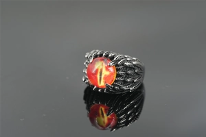 Macro shot of evil eye ring with red dragon pupil and detailed vintage feather texture