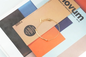 Detailansicht eines goldenen Smile-Bar-Armbands mit Karabinerverschluss und Gliederkette