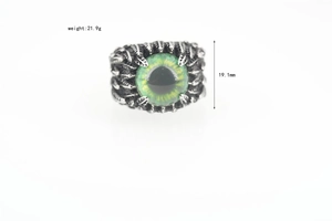 Macro shot of punk evil eye ring with silver feather textures and yellow-green eyeball