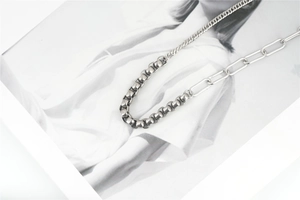 Detail of silver stainless steel Cuban necklace featuring three-segment splice chain links