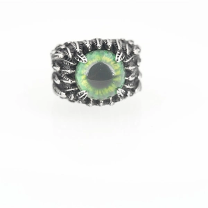 Gothic evil eye feather ring in silver with green pupil on a white background