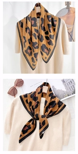Detail of leopard print silk scarf paired with a beige sweater for a luxury look