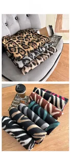 Close-up detail of leopard and zebra print patterns on thick faux cashmere winter scarves