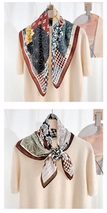 Détail d'un foulard en soie à imprimé géométrique noué sur un haut en tricot beige